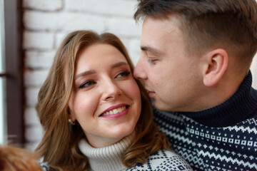 Image of young happy man kissing and hugging beautiful woman