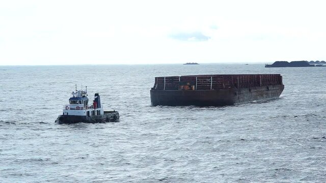 the barge is being towed by the tugboat