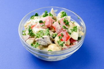 Bowl of vegetable salad with grilled meta, tomatoes, mushrooms. Mayonnaise salad in a bowl.