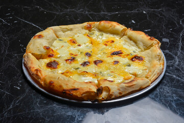 A Pepperoni pizza on black marble table background. Traditional Italian cuisine concept.