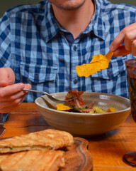 Young man eating salad in restaurant or diner. Georgian cuisine restaurant concept. Vegetable salad with lavash roll.