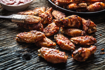 Chicken wings barbeque in a cast iron baking dish with BBQ sauce