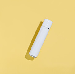 white aerosol spray bottle on a yellow background. mock up for your design. classic shaped tin can for home cleaning brands, hair or disinfecting product. 