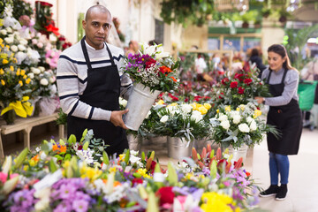 Male flower seller prepares a luxury bouquet at a flower shop