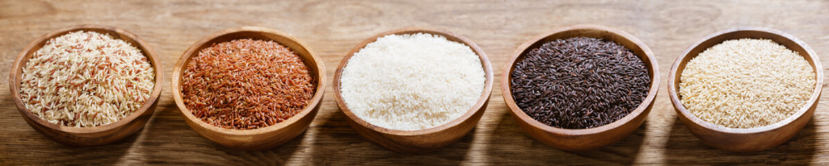 Various types of rice : white, brown, mix grain, black rice and red in a bowls