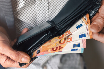 The businessman puts 50 euros in his wallet.