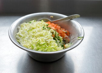 metal bowl with fresh salad of tomatoes, cabbage and cucumbers, eat cooking