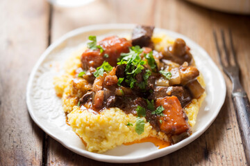 Boeuf bourguignon with carrots, mushrooms, topped with parsley served with polenta  - 409805059