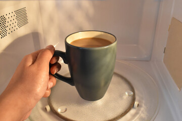 Cup of tea or coffee in microwave.  Concept of heating your drink in microwave.