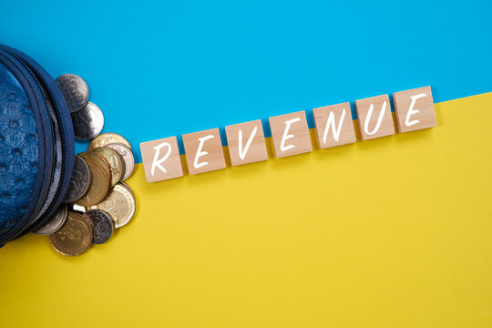 Concept image of Revenue with coins as props over striking blue and yellow background