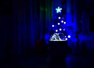 Garland in a circle on the background of a Christmas tree, blurr. Comfort and New Year's romance.