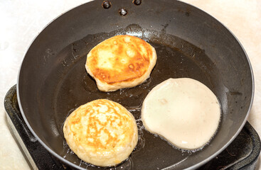 Cooking pancakes in a hot skillet in boiling oil. Homemade pancakes. Close up..