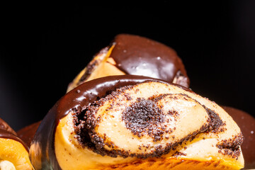 Rolled buns with poppy seeds, covered with chocolate icing