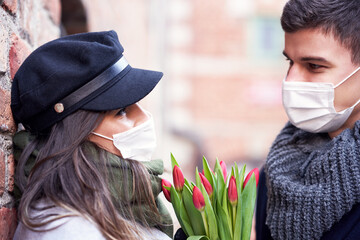 Happy couple celebrating Valentines Day in masks during covid-19 pandemic