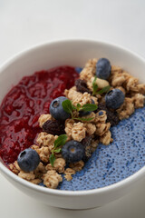 Breakfast smoothie bowl with granola on white background