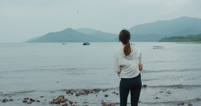 Woman throw a stone to the sea
