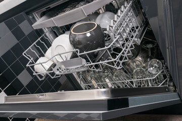 open dishwasher with clean dishes inside, close-up