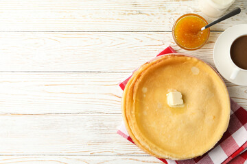 Concept of tasty breakfast with thin pancakes on white wooden table