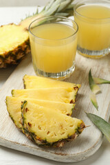Concept of breakfast with pineapple and glasses with juice on wooden table