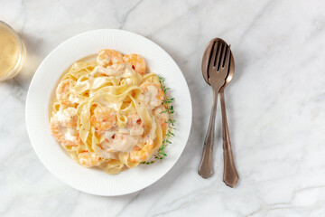 Pappardelle pasta with shrimps and cream sauce, shot from the top with a place for text