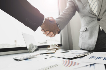 Two business people shake hands after a business deal is reached In the office area