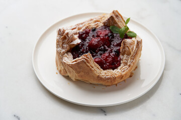 Puff pastry cake with berries on wooden background.