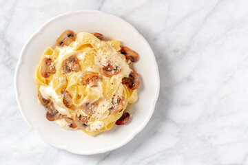 Pasta with portobello mushrooms, cream sauce and cheese, overhead shot with copyspace