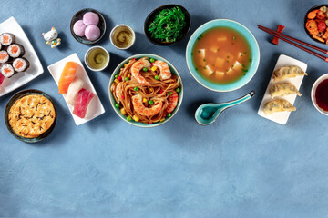 Japanese cuisine design template with a place for text. Sushi, miso soup, udon, tea etc, a flat lay, shot from above on a blue background