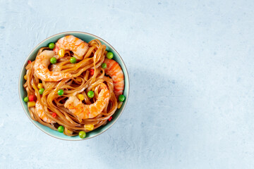 Noodles, stir-fried with shrimps and vegetables, overhead shot with a place for text