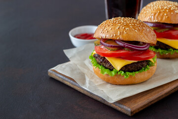 Burgers with cutlet, tomato, lettuce, cucumber, onion and cheese. American cuisine. Fast food. Cheeseburger.
