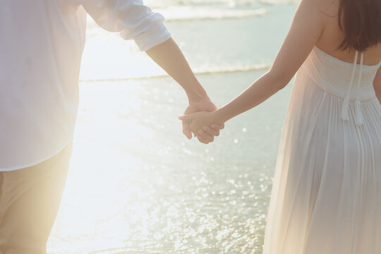 Love young couple holding hands and running on the beach. Holiday and vocation concept.