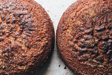 Two healthy brown sugar cinnamon cake on textured natural stone background. The image shows crumbs...