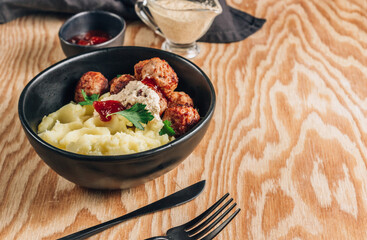 Swedish meatballs with mashed potatoes, gravy and lingonberry jam on wooden background. Selective focus
