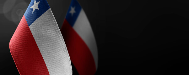 Small national flags of the Chile on a dark background