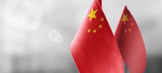Small national flags of the China on a light blurry background