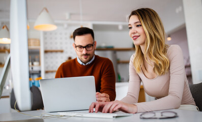 Happy successful business partners working at meeting in office