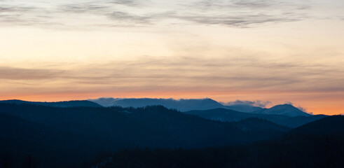 Fototapeta premium Panorama of the silhouette of mountains and forest on the background of sunset