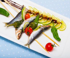 Grilled sardines with fresh vegetables served with lime and balsamic pasta on plate