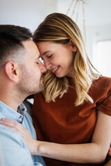 Cute couple in love hugging and having great time together at home