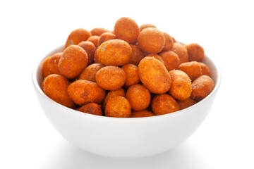 Fototapeta na wymiar Crunchy Peanut in a white ceramic bowl, made with besan coated peanuts. Pile of Indian spicy snacks (Namkeen), under backlight, side view, against the white background.