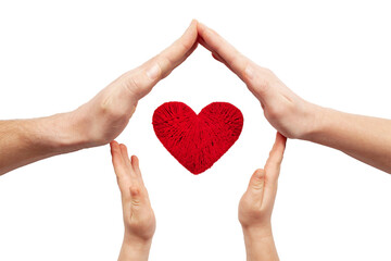 Family love. Hands of parents and child around a red heart isolated on white background.