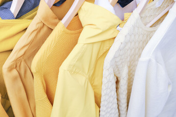 Feminine clothes in yellow color on hanger. Spring cleaning home wardrobe. Minimal fashion concept....