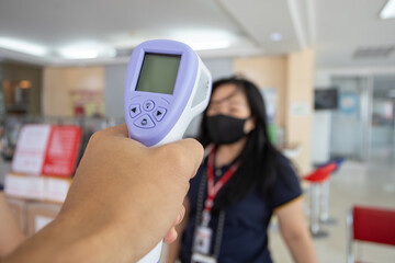 female Asia person being measured body temperature with thermometer. quarantine or virus outbreak concept.