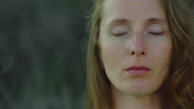 Slow motion. Face of Young Woman in Freckles with Closed Eyes. Meditation. Calming down.