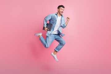 Fototapeta na wymiar Full length body size photo of jumping programmer with computer running smiling isolated on pastel pink color background