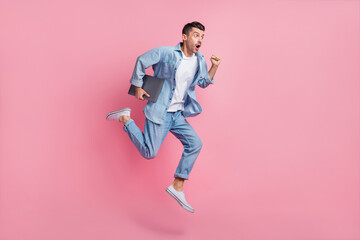 Fototapeta na wymiar Full length body size view of nice motivated energetic guy jumping carrying laptop running fast isolated on pink pastel color background