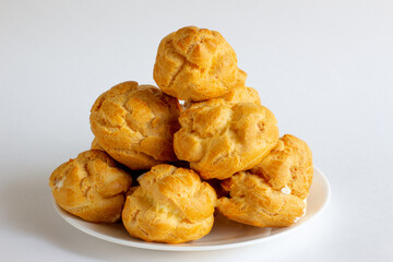 Eclairs on white plate on a whight background. eclairs with cream.
