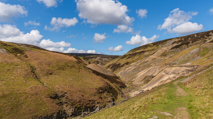 Walking at the Gunnerside Gill with the Bunton Mine and Blakethwaite Mine in the background, North Yorkshire, England, UK