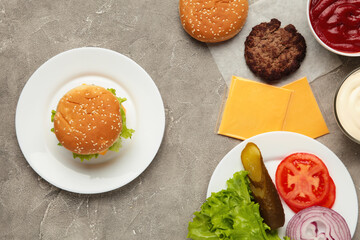 Homemade burger with ingredients on a grey background