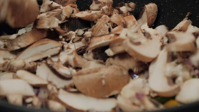 Motion controlled slow motion shot of mushrooms in a cooking pan